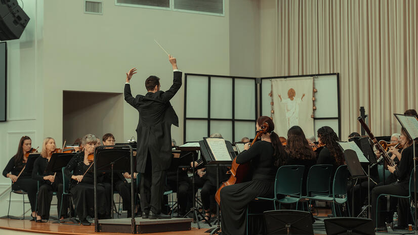 Orchestra in rehearsal — Indian River Pops Orchestra Conductor leading a seated orchestra during a full ensemble rehearsal