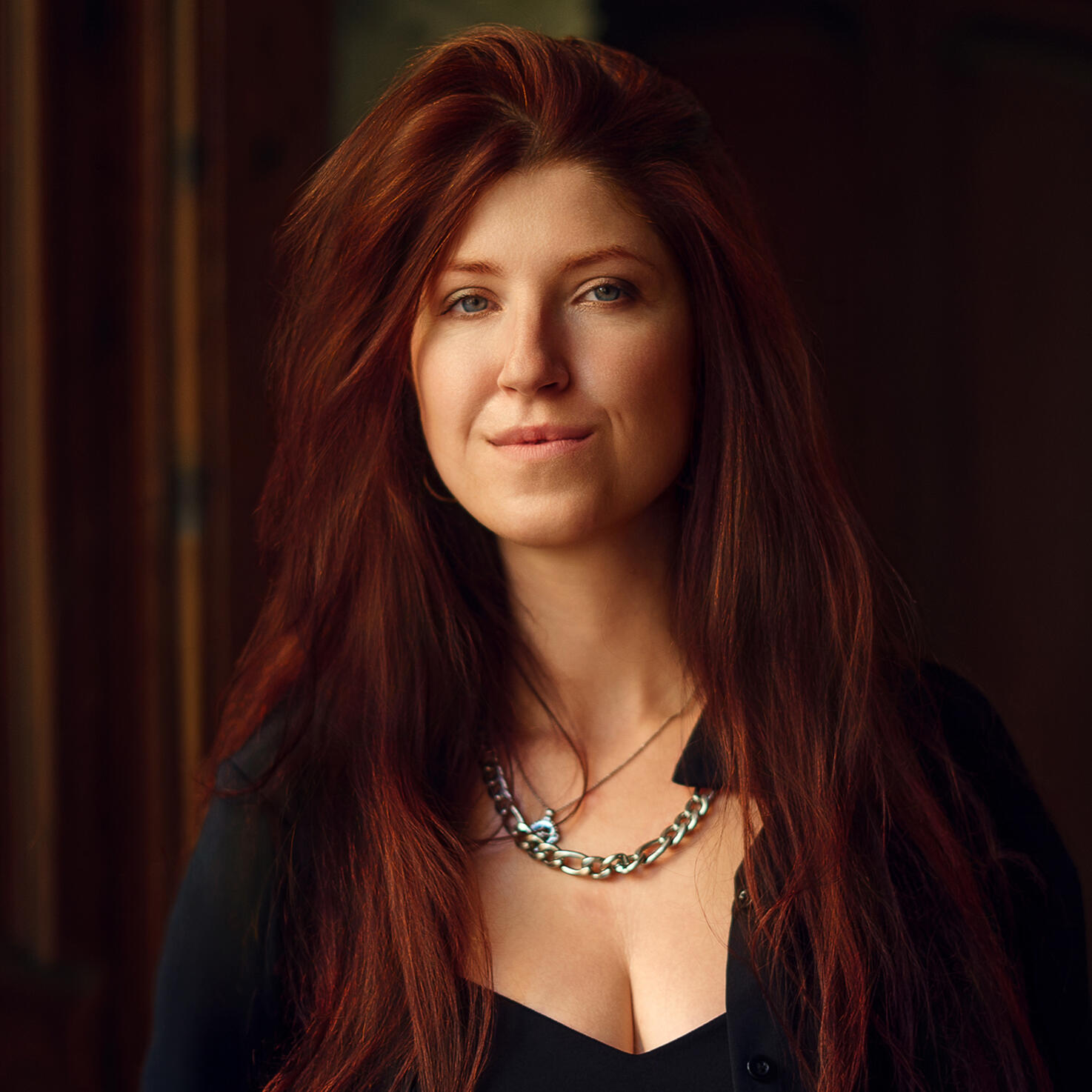 Alisa Zenkina — portrait and event photographer based in Valencia Portrait of photographer Alisa Zenkina with long red hair, wearing black and looking directly at the camera